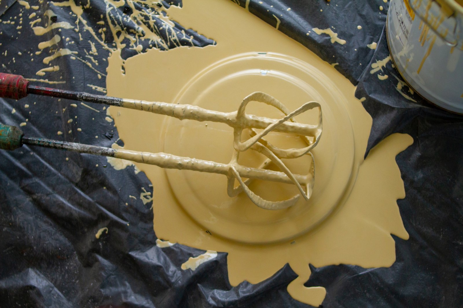 mixer's paddles are covered in epoxy resin and have been placed on the lid of the bucket